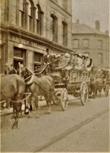 a sepia toned photograph of several horse-and-carriages in front of a building, the front of which reads "Argyle Theatre"