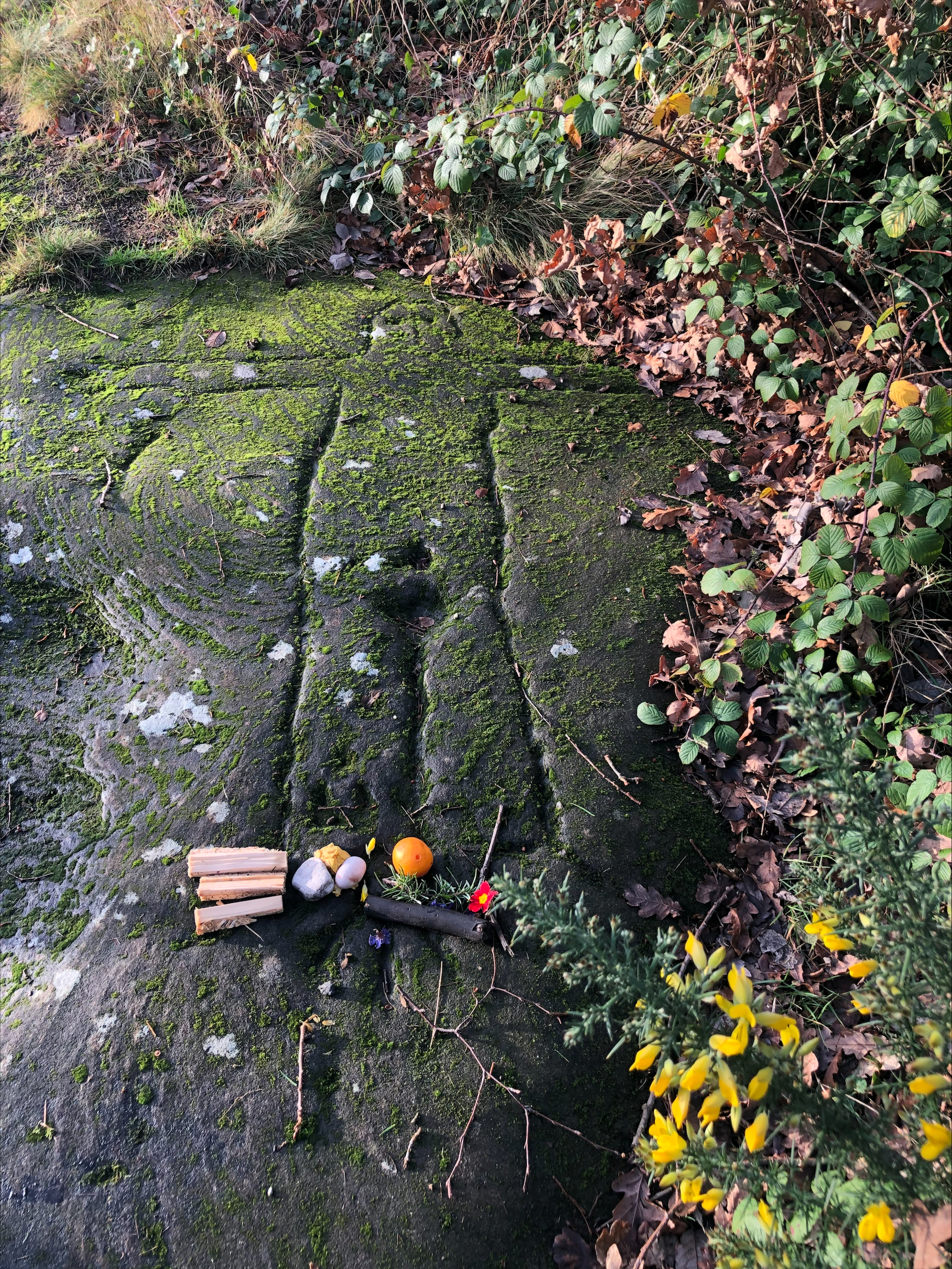 photograph of a human figure carved quite crudely into a stone outdoor floor