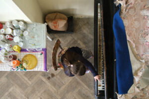 photograph by Igor Chekachkov taken from above (birds-eye view) of a woman playing a piano.