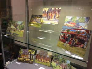 photograph from a display case showing two paintings by Keith Gardner of Birkenhead Park.