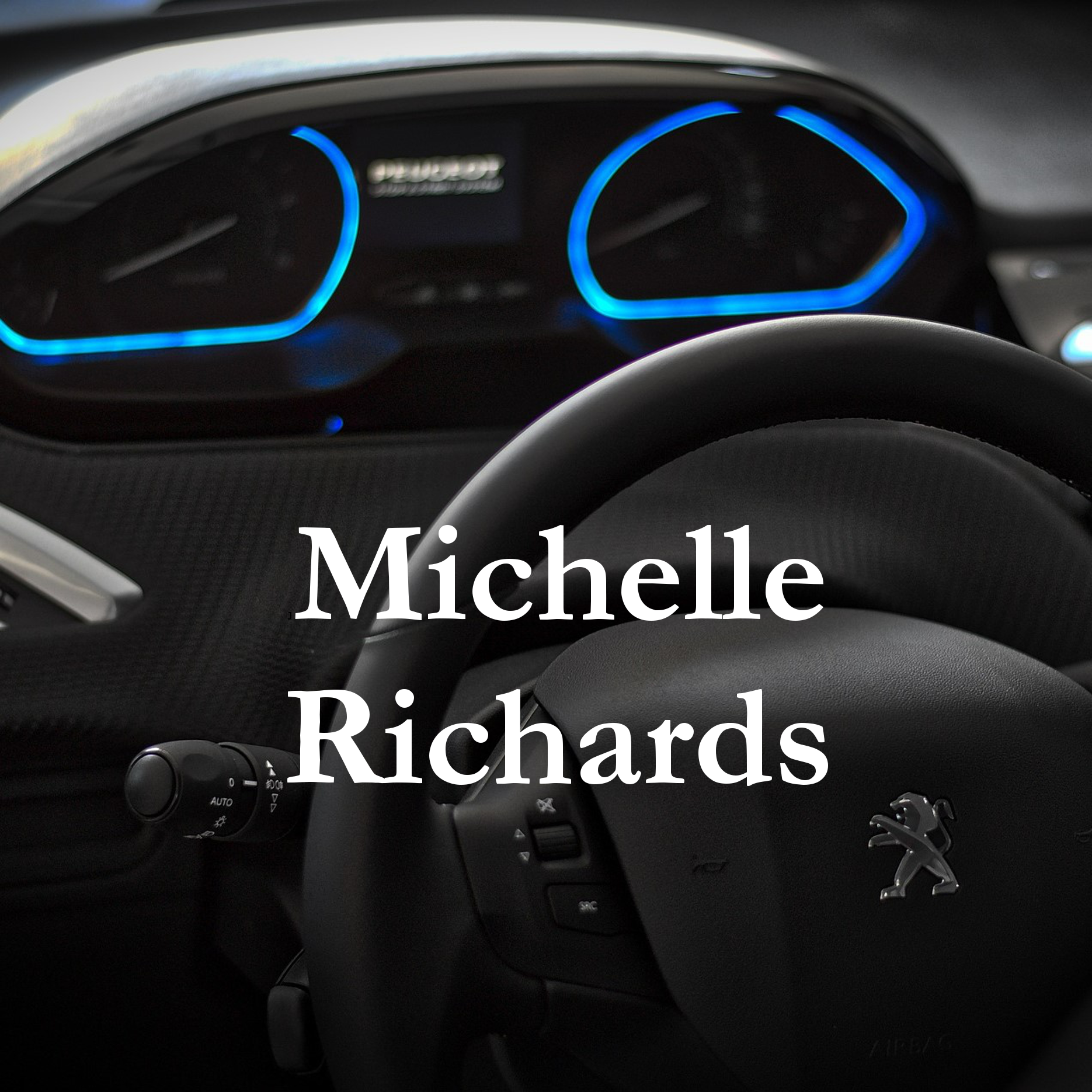 photograph of a car interior showing the steering wheels and the dash illuminated in blue, with the author's name - Michelle Richards - written in white over the top